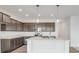 Beautiful kitchen featuring modern lighting and appliances, an island, and hardwood floors at 908 Stonehaven Dr, Indianapolis, IN 46239