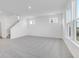 A large living room featuring gray carpet, white walls, and many large windows providing natural light at 908 Stonehaven Dr, Indianapolis, IN 46239