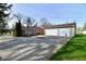 View of the house with a detached two car garage and a large parking area at 7912 E St Joseph St, Indianapolis, IN 46219