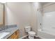 Bathroom featuring a granite countertop, toilet and white tiled shower and tub at 12820 University Cres # 2D, Carmel, IN 46032
