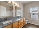 Bathroom featuring dual sinks with granite countertops, wood cabinets, and tile flooring at 12820 University Cres # 2D, Carmel, IN 46032