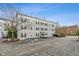 Apartment building with gray facade, black shutters, and parking spots at 12820 University Cres # 2D, Carmel, IN 46032