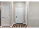 Hallway featuring several white doors and neutral wall tones, and wood-look floors at 12820 University Cres # 2D, Carmel, IN 46032