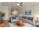 Staged living room with furniture, including a comfortable sofa and a view of the kitchen at 12820 University Cres # 2D, Carmel, IN 46032