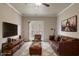 Staged living room featuring a leather couch, area rug, and bright lighting at 12820 University Cres # 2D, Carmel, IN 46032