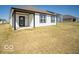 View of the house's white siding, dark trim, covered porch, and expansive backyard lawn at 273 Lar Lan Dr, Danville, IN 46122