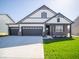 Charming two-story home with a three-car garage, landscaped yard, and a mix of siding and brick details at 273 Lar Lan Dr, Danville, IN 46122