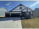 Charming home showcasing a black three-car garage, white siding, and brick accents for an inviting curb appeal at 273 Lar Lan Dr, Danville, IN 46122