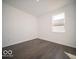 Minimalist bedroom with hardwood floors, a window, and white walls at 287 Lar Lan Dr, Danville, IN 46122