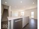 Open kitchen with island, stainless steel dishwasher, white countertops, and easy access to stairs and backyard at 287 Lar Lan Dr, Danville, IN 46122