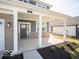 Covered front porch with brick accents and white pillars leading to the front door of a new home at 287 Lar Lan Dr, Danville, IN 46122