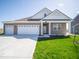 Charming single-story home with a brick facade, three-car garage, and well-manicured lawn at 301 Lar Lan Dr, Danville, IN 46122