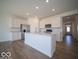 Bright kitchen features white cabinets, stainless appliances, island, and wood-look floors at 301 Lar Lan Dr, Danville, IN 46122