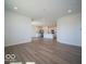Open kitchen and living area features white cabinets, stainless appliances, island and wood-look floors at 301 Lar Lan Dr, Danville, IN 46122