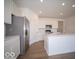 Modern kitchen featuring stainless steel appliances, white cabinets, an island, and wood-look floors at 301 Lar Lan Dr, Danville, IN 46122
