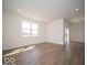Sun-drenched living room featuring wood-look floors and large windows for ample natural light at 301 Lar Lan Dr, Danville, IN 46122
