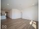Living room features wood-look floors flowing into kitchen with white cabinets and stainless appliances at 301 Lar Lan Dr, Danville, IN 46122