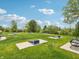 Well-maintained lawn with mature trees, park benches and cornhole game in common recreation area at 301 Lar Lan Dr, Danville, IN 46122