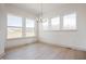 Open dining room with hardwood floors, three large windows and a modern chandelier, ready for your personal touches at 798 Leila Mae Ln, Westfield, IN 46074