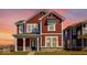 Two-story craftsman home with red siding, white trim, covered porch, and professionally landscaped yard at 9344 Anthem Ave, Plainfield, IN 46168