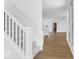 Hallway featuring wood floors, a carpeted staircase, white railings and walls, leading to open living space at 9344 Anthem Ave, Plainfield, IN 46168