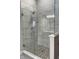 Modern glass enclosed shower with marble tile surround and pebble floor at 1213 Cottage Ave, Indianapolis, IN 46203