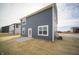 Backyard showcasing the home's exterior with a gray siding, patio, and well-manicured lawn at 7904 Magnolia St, New Palestine, IN 46163