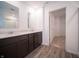 Bathroom featuring a double vanity, gray wood flooring, and an open view to the walk-in closet at 7904 Magnolia St, New Palestine, IN 46163