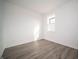 Bright bedroom featuring vinyl flooring, white walls, and a single window bringing in natural light at 7904 Magnolia St, New Palestine, IN 46163
