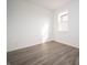 A well-lit bedroom with light gray wood floors and a large window at 7904 Magnolia St, New Palestine, IN 46163