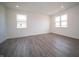 Bright bedroom featuring vinyl flooring, white walls, and two windows bringing in natural light at 7904 Magnolia St, New Palestine, IN 46163