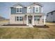 Charming two-story home boasts a modern exterior with a combination of brick and blue siding and manicured lawn at 7904 Magnolia St, New Palestine, IN 46163