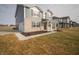 A modern two-story home featuring a light brick and blue siding exterior, complemented by a lush lawn at 7904 Magnolia St, New Palestine, IN 46163
