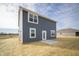 Home exterior featuring gray siding, white trim, and a small patio area, perfect for outdoor enjoyment at 7904 Magnolia St, New Palestine, IN 46163