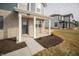 Inviting front porch with white columns, gray brick facade and well-manicured flower beds at 7904 Magnolia St, New Palestine, IN 46163