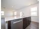 Modern kitchen island featuring stainless steel appliances, a sink and quartz countertops at 7904 Magnolia St, New Palestine, IN 46163