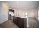 Kitchen island with a stainless steel dishwasher and dark cabinetry with stainless steel refrigerator at 7904 Magnolia St, New Palestine, IN 46163