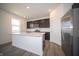 Well-lit kitchen featuring stainless steel appliances, a center island, and sleek dark cabinets at 7904 Magnolia St, New Palestine, IN 46163