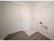 Well-lit laundry room with practical features and wood-look flooring at 7904 Magnolia St, New Palestine, IN 46163
