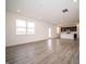 Expansive living area featuring light gray wood floors, and a kitchen area with bright white counters at 7904 Magnolia St, New Palestine, IN 46163