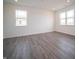 Spacious living room with light gray wood floors, recessed lighting, and windows allowing natural light at 7904 Magnolia St, New Palestine, IN 46163