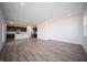 Open-concept living room featuring wood-style flooring and seamless flow into the modern kitchen at 7904 Magnolia St, New Palestine, IN 46163