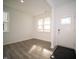 Bright living room featuring vinyl flooring, white walls, and large windows bringing in natural light at 7904 Magnolia St, New Palestine, IN 46163