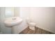 Powder room with pedestal sink, modern toilet, neutral paint and flooring at 7904 Magnolia St, New Palestine, IN 46163