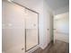 Shower featuring sliding glass door, white tile walls, and gray wood flooring at 7904 Magnolia St, New Palestine, IN 46163