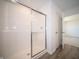 Bathroom showcasing modern shower with a glass door, complemented by wood-look flooring at 7904 Magnolia St, New Palestine, IN 46163