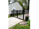 Secure backyard featuring a black metal gate, potted flowers and a well-maintained lawn at 5441 E 17Th St, Indianapolis, IN 46218