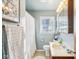 Clean bathroom with light blue walls, wood vanity, and a shower/tub combo at 5441 E 17Th St, Indianapolis, IN 46218
