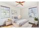 Well-lit bedroom with gray bedding, hardwood floors, and two windows at 5441 E 17Th St, Indianapolis, IN 46218