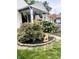 Beautiful front yard landscaping featuring a manicured lawn, decorative stone border and mature trees at 5441 E 17Th St, Indianapolis, IN 46218